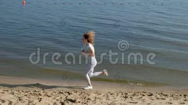 一个<strong>身材好</strong>的年轻女子在黎明时在海里从事体操。 她戴着耳机沿着海岸跑